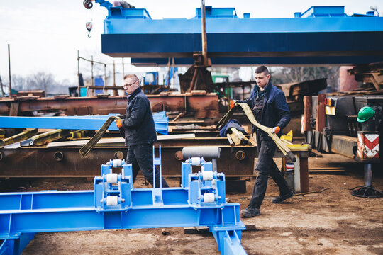 Manual workers working at shipyard construction site