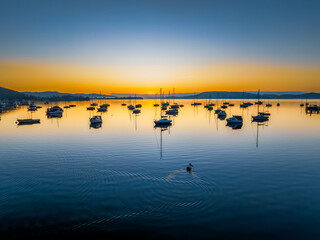 Naklejka premium Winter sunrise with clear skies and boats on the water
