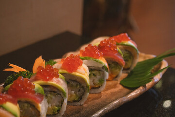 Sushi Rolls with eel, salmon, avocado, flying fish caviar and Cream Cheese inside isolated on white
