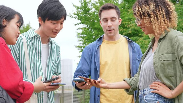 スマホを見せ合う多国籍若者グループ