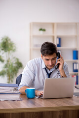 Fototapeta premium Young male employee working in the office