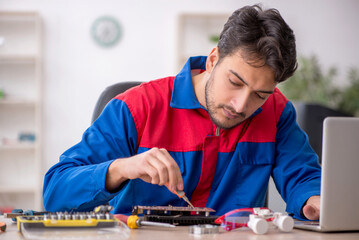 Young male repairman repairing computer