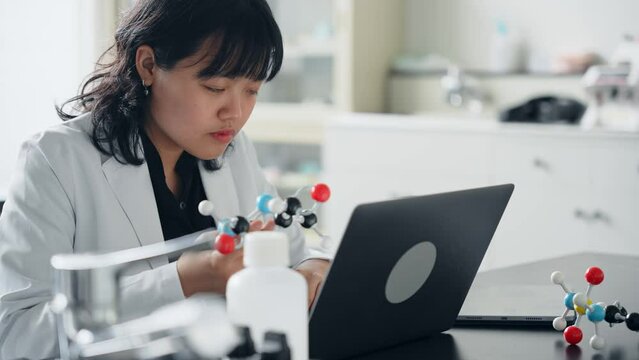 分子模型を見る女性研究者