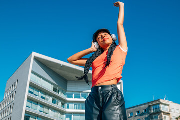 Fototapeta premium urban girl with headphones enjoying listening to music