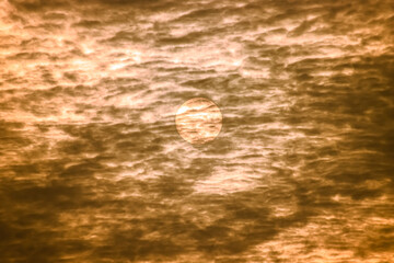 Sunset and clouds in the sky. The sun is behind the clouds.