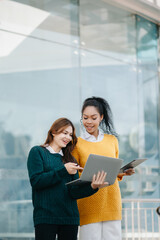 Asian Students are studying the campus park. Young people are spending time together. Reading book, working with laptop, tablet and communicating while sitting .