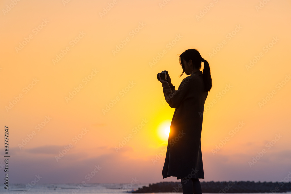 Canvas Prints silhouette of woman use camera to take photo at sunset in the beach