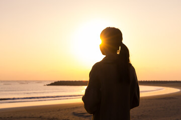 Silhouette of woman enjoy the sunset in the beach