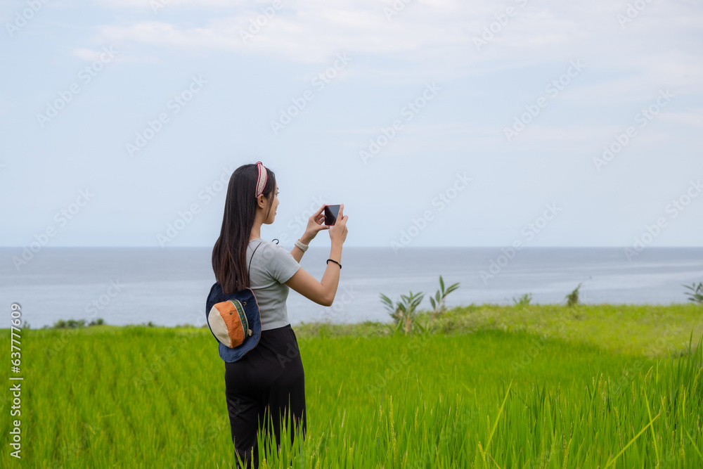 Wall mural Tourist woman use cellphone to take photo in countryside