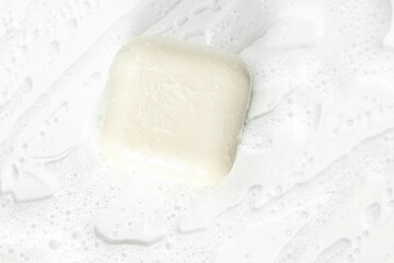 Handmade soap and soap foam on a white background.A piece of soap a hygienic concept on a white background is a place to copy. Small business
