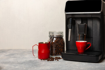 Modern coffee machine with a cup on the kitchen table. Coffee house. Modern espresso coffee machine...