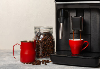 Modern coffee machine with a cup on the kitchen table. Coffee house. Modern espresso coffee machine with a cup in the kitchen. Preparation of a fragrant hot drink. Place for text.Copy space.