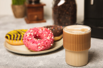 Modern coffee machine with a cup and donut on the kitchen table. Coffee house. Modern espresso coffee machine with a cup in the kitchen. Preparation of a fragrant hot drink. Place for text.Copy space.