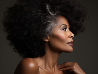 Beautiful and confident African woman in her 50s with styled long curly hair. Concept of African mature haircare.