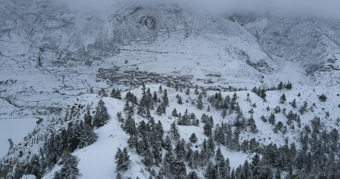 Manang Nepal Snowy Village Winter Annapurna Region. Drone Shot Captures Forward Motion. Snowy Mountains, Forest, Beauty of Nature Highlighted. 4K Travel Video