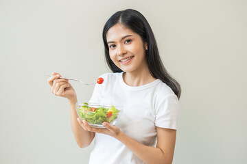 Diet concept, happy asian young woman, girl hand use fork at tomato with fresh vegetable, green salad, eat nutrition food low fat to good body on background. female getting weight loss for healthy.