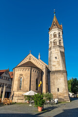 Fototapeta na wymiar Die Johanniskirche, ein Wahrzeichen von Schwäbisch Gmünd auf dem Marktplatz in der Altstadt mit leerem Straßencafe bei schönem Sommerwetter