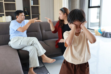 Fototapeta premium Young little asian boy depressed and upset while parent fighting and arguing