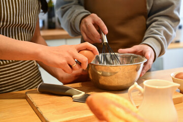 Cropped shot of young couple making pancakes for breakfast together in kitchen.