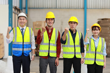 Group of technician engineer and businessman in protective uniform with hardhat standing and raising hands celebrate successful together or completed deal commitment at industry manufacturing factory