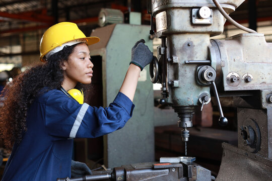 Technician Engineer Or Worker Woman In Protective Uniform With Safety Hardhat Maintenance Operation Or Checking Lathe Metal Machine At Heavy Industry Manufacturing Factory. Metalworking Concept