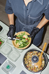 Top view closeup of young woman doing healthy meal prep at home, shot with flash