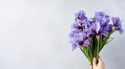Fototapeta na wymiar Mockup of a bouquet containing blue and purple irises on a light gray background for celebrations like birthdays March 8th International Women s Day and to expre