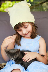 Obraz premium Pretty little girl caress the domestic animal.