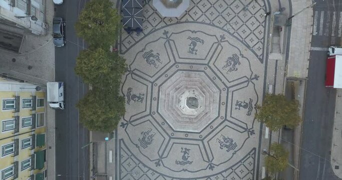 Aerial shot captures the scenic Cam&otilde;es Square in Chiado, Lisbon, Portugal, showcasing its architectural charm and the vibrant ambiance of the area.