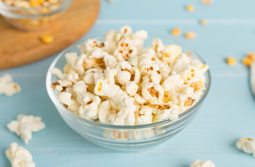 Prepared popcorn with ingredients on wooden table