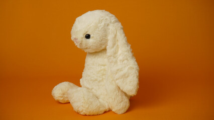 Plush bunny on a yellow background.