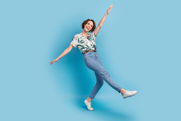 Obraz premium Full length photo of charming carefree lady wear print shirt walking having fun isolated blue color background