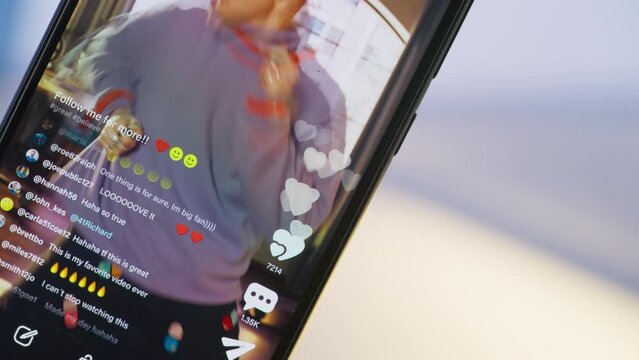 Close Up on Smartphone Screen: Likes Button and Counter for Male Dancer Streaming a Choreography Online on Social Media Mobile App. Fans Cheering and Commenting, Supporting Their Favorite Influencer