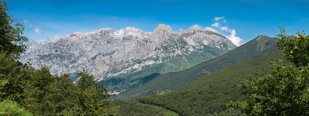 Fototapeta na wymiar Panoramic view at the Picos de Europa, or Peaks of Europe, a mountain range extending for about 20 km, forming part of the Cantabrian Mountains in northern Spain
