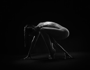 Beautiful sexy fitness girl with a great figure flexing her perfect body in a yoga pose at the studio. Black and white photo - obrazy, fototapety, plakaty