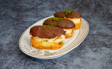Eclairs with chocolate topping on serving plate
