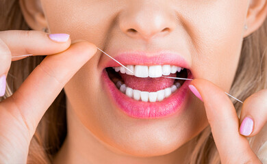 Healthy teeth concept. Teeths Flossing. Oral hygiene and health care. Smiling women use dental floss white healthy teeth. Dental flush - woman flossing teeth. Dental floss. Taking care of teeth
