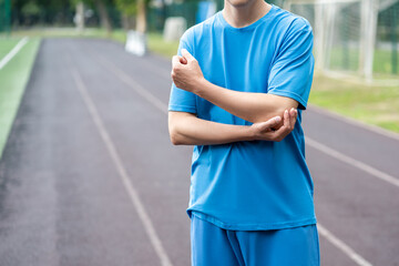 Diseases of the elbow joint, bone fracture and inflammation, athletic man on a running track after...