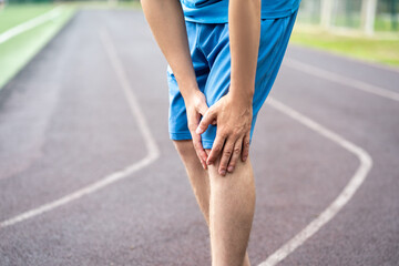 Diseases of the knee joint, bone fracture and inflammation, athletic man on a running track after...