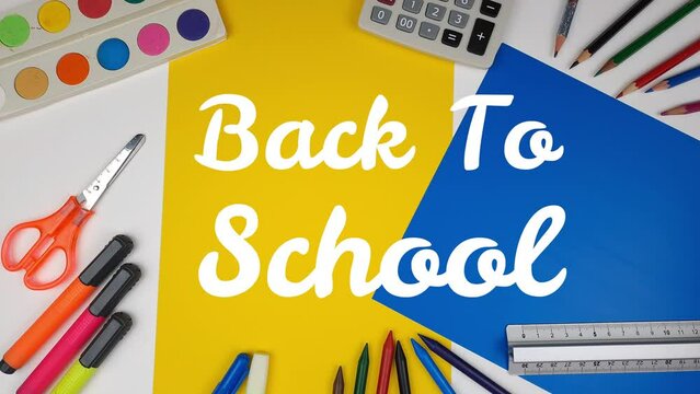 Back to school illustration on blackboard. The hand moves and shows an inscription. Crayons, ruler, tempera and stationery for school.
