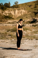 Woman doing yoga and standing on nails in the desert at sunset.The concept of yoga and standing on nails