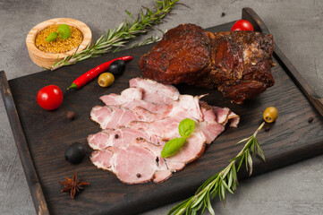 boiled and smoked pork delicacies on a dark wooden board