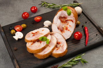 boiled smoked chicken rolls on a dark wooden board