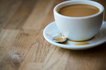 cup of coffee with milk on wooden table