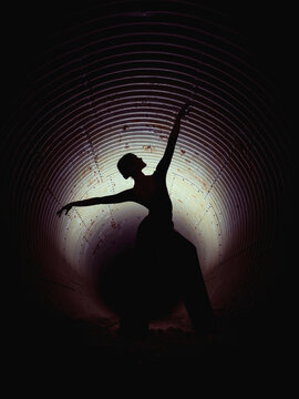 Silhouette of female ballerine dancer in darkness