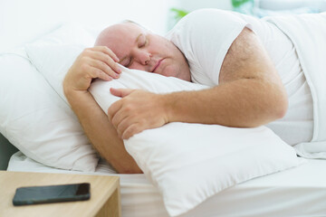 Caucasian white oversize body - fat man sleeping on the bed in bedroom close up. Health care and...
