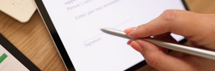 Business woman puts her signature on contract on her tablet.