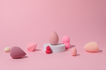 Cosmetic sponges on pink background, space for text