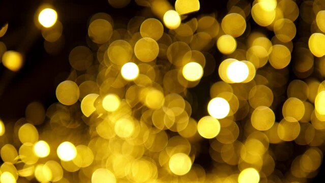 A close-up of a garland with golden lights hanging in the park in the evening, a blurry image. Bokeh. Sharp and blurry image.