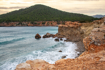 Green mountain in a rocky shore